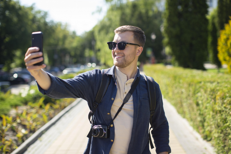 Male traveler with camera local park